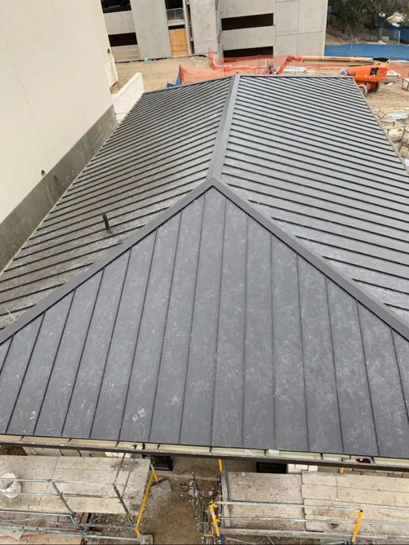 Commercial metal roof construction with crane equipment in Bartonville